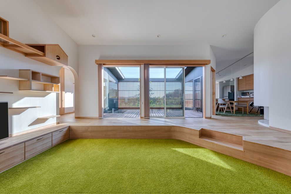 На фото: открытая гостиная комната среднего размера в скандинавском стиле с белыми стенами, ковровым покрытием, отдельно стоящим телевизором, зеленым полом, потолком с обоями и обоями на стенах с