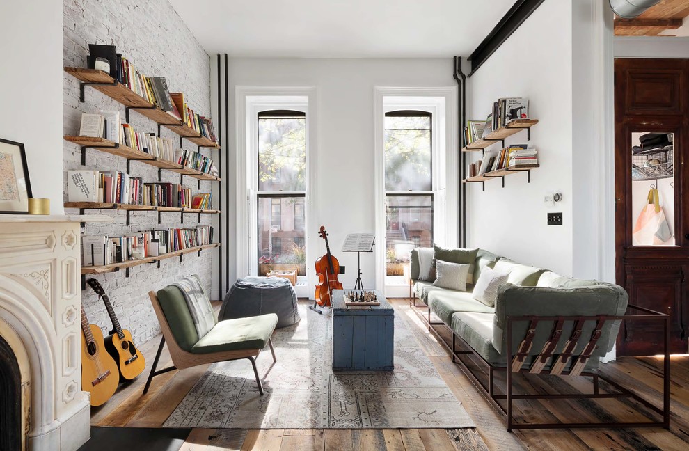 Inspiration for a mid-sized industrial open concept living room in New York with a standard fireplace, no tv, brown floor, a music area, white walls and dark hardwood floors.
