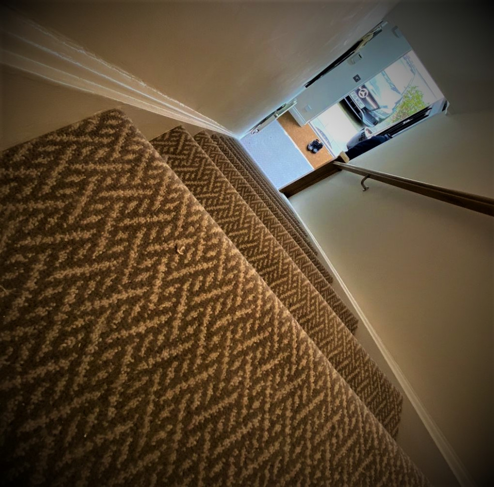 Mid-sized trendy carpeted straight wood railing staircase photo in Hertfordshire with carpeted risers