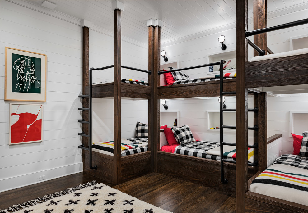 Photo of a large country kids' bedroom in New York with white walls, dark hardwood floors and brown floor.