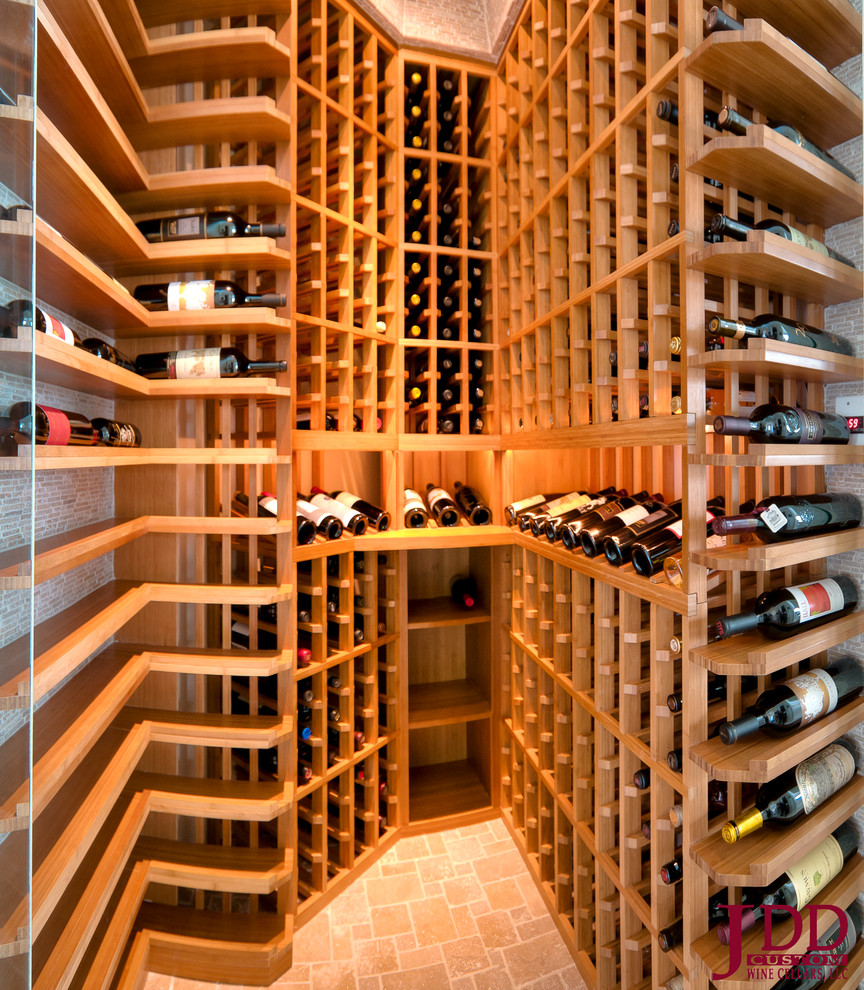 Photo of a mid-sized modern wine cellar in Orange County with travertine floors and display racks.