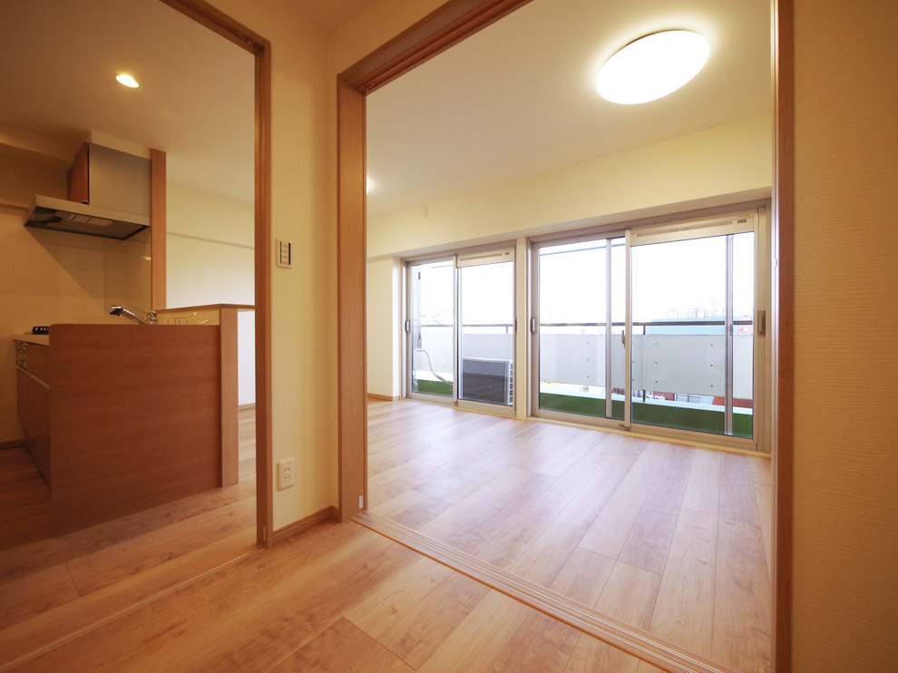 This is an example of a scandinavian open concept family room in Tokyo with white walls, light hardwood floors and beige floor.