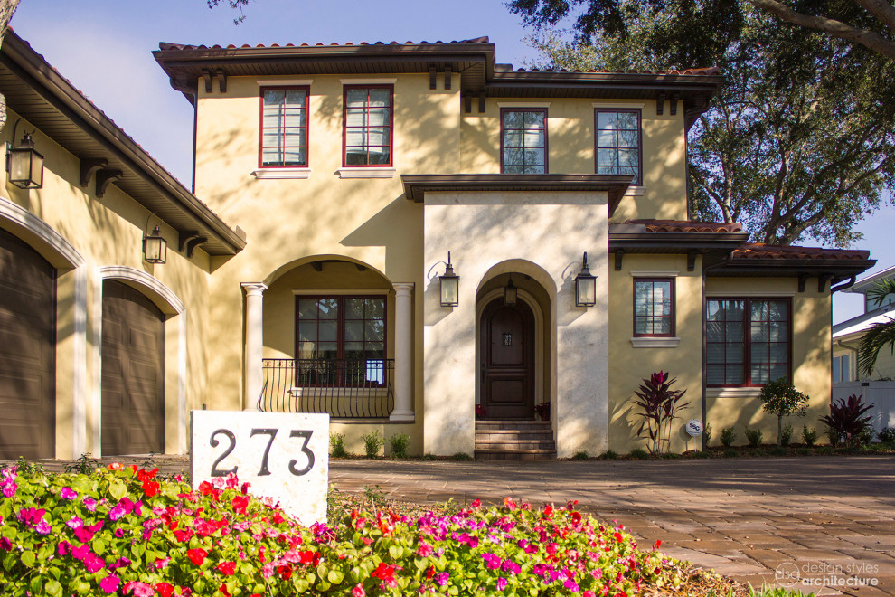 Example of a tuscan yellow two-story stucco exterior home design