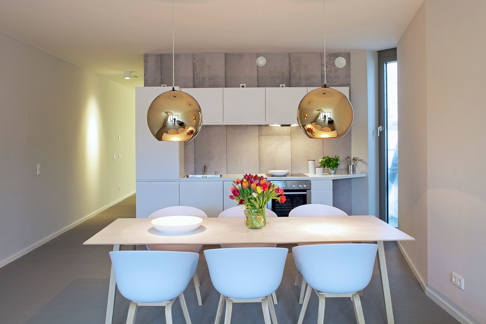 Photo of a mid-sized contemporary open plan dining in Hamburg with white walls and concrete floors.
