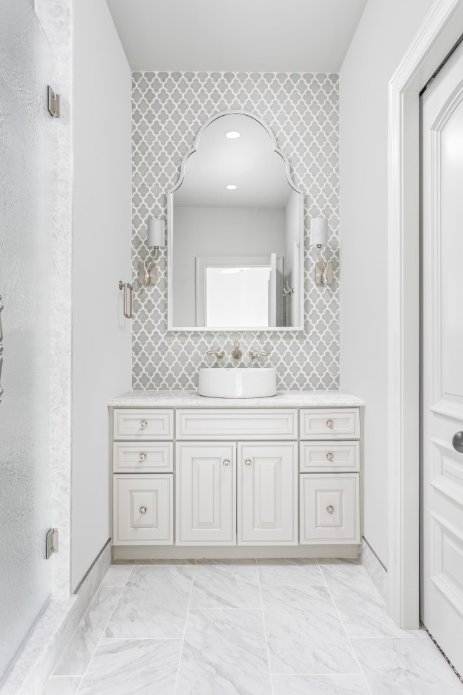 This is an example of a mid-sized mediterranean 3/4 bathroom in Indianapolis with beaded inset cabinets, white cabinets, an alcove shower, gray tile, white walls, a vessel sink, white floor, a hinged shower door and white benchtops.
