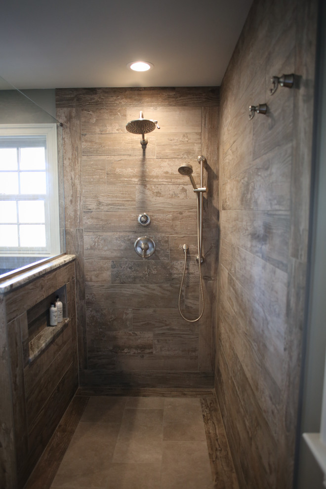 Inspiration for a mid-sized country master bathroom in Philadelphia with brown cabinets, a curbless shower, a two-piece toilet, brown tile, porcelain tile, grey walls, porcelain floors, an undermount sink, granite benchtops, beige floor, an open shower and flat-panel cabinets.