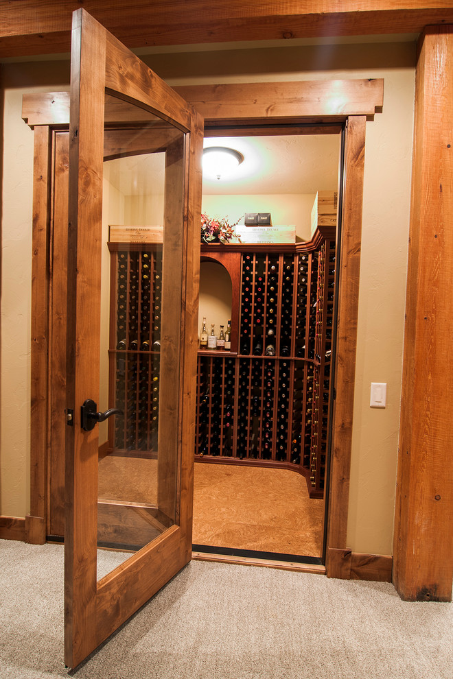 Mid-sized country wine cellar in Denver with cork floors and storage racks.