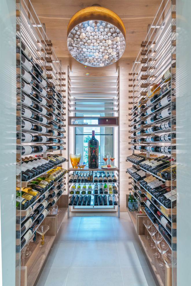 This is an example of a contemporary wine cellar in Houston with storage racks and grey floor.