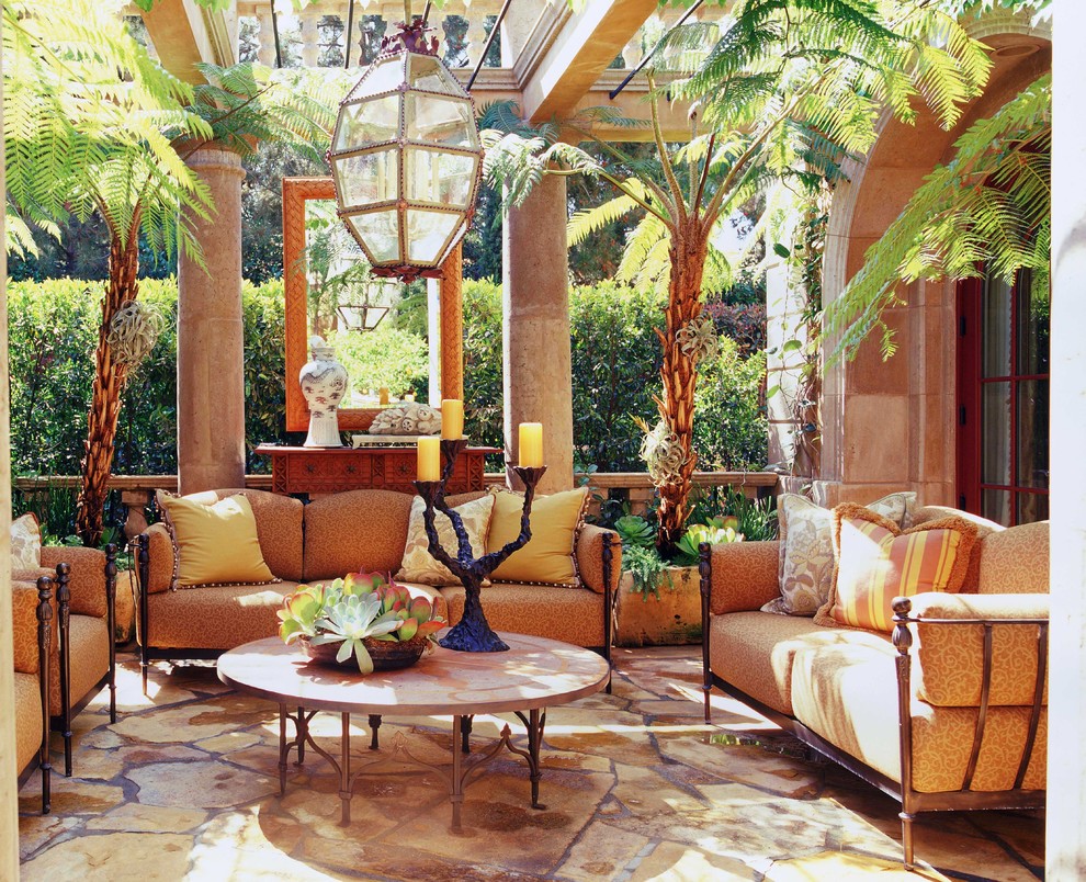 Inspiration for a mediterranean patio in Orange County with natural stone pavers and a pergola.