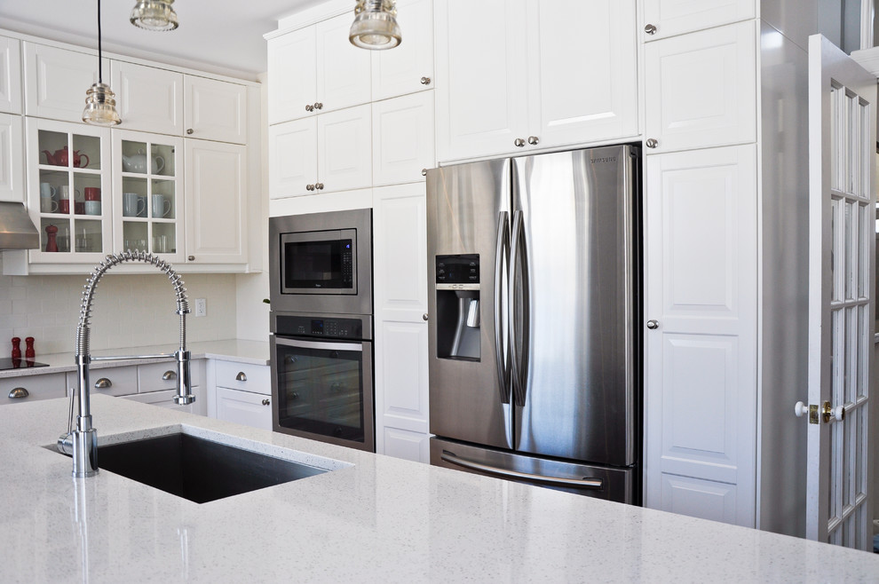 Eat-in kitchen - transitional eat-in kitchen idea in Ottawa with an undermount sink, raised-panel cabinets, white cabinets, quartz countertops, white backsplash, porcelain backsplash, stainless steel appliances and an island