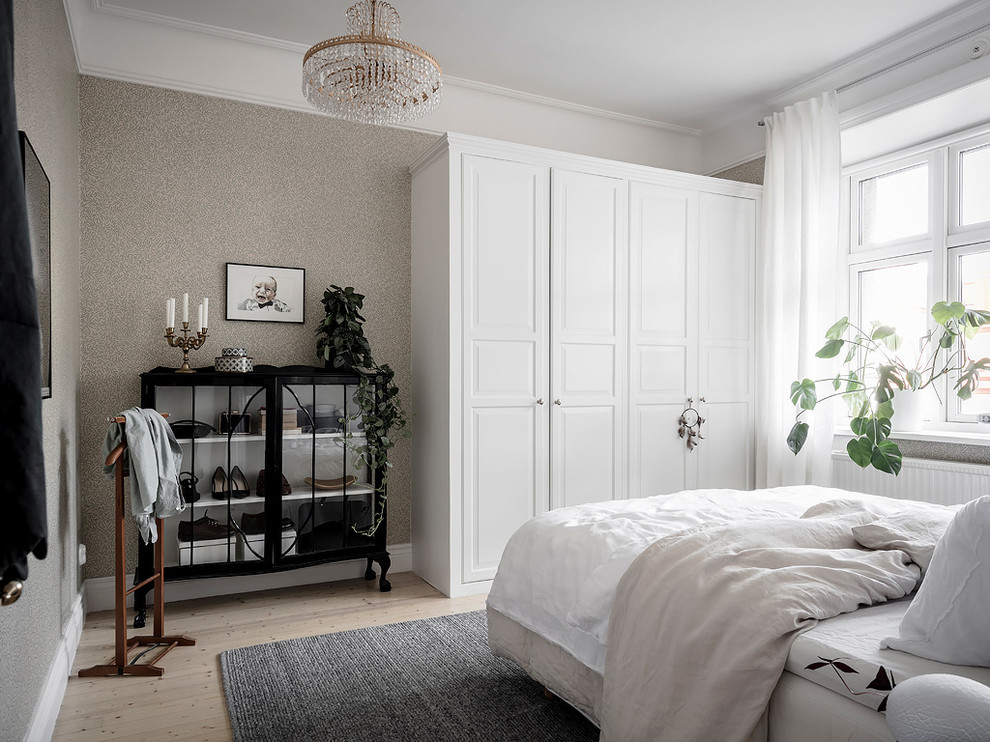 Scandinavian guest bedroom in Gothenburg with grey walls, light hardwood floors and beige floor.