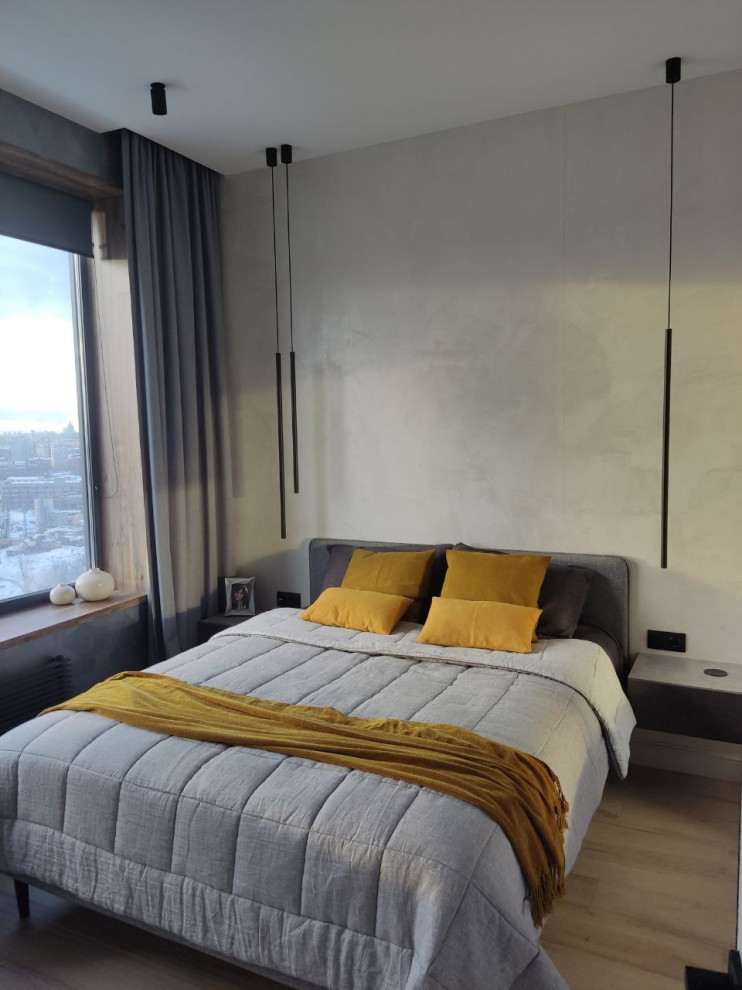 На фото: хозяйская, серо-белая спальня среднего размера: освещение в современном стиле с бежевыми стенами, полом из керамогранита и коричневым полом с
