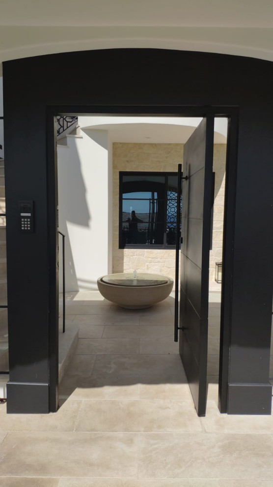 Esempio di una porta d'ingresso moderna di medie dimensioni con pareti beige, una porta a pivot, una porta nera e pavimento beige