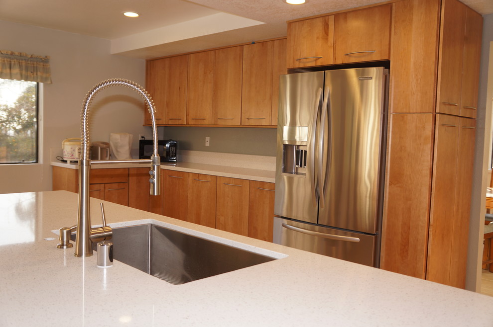 Photo of a mid-sized modern u-shaped eat-in kitchen in Los Angeles with a single-bowl sink, flat-panel cabinets, light wood cabinets, quartz benchtops, white splashback, stone slab splashback, stainless steel appliances, porcelain floors and with island.