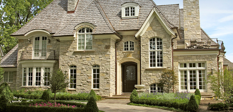 Photo of a large arts and crafts three-storey beige exterior in Orlando with stone veneer.