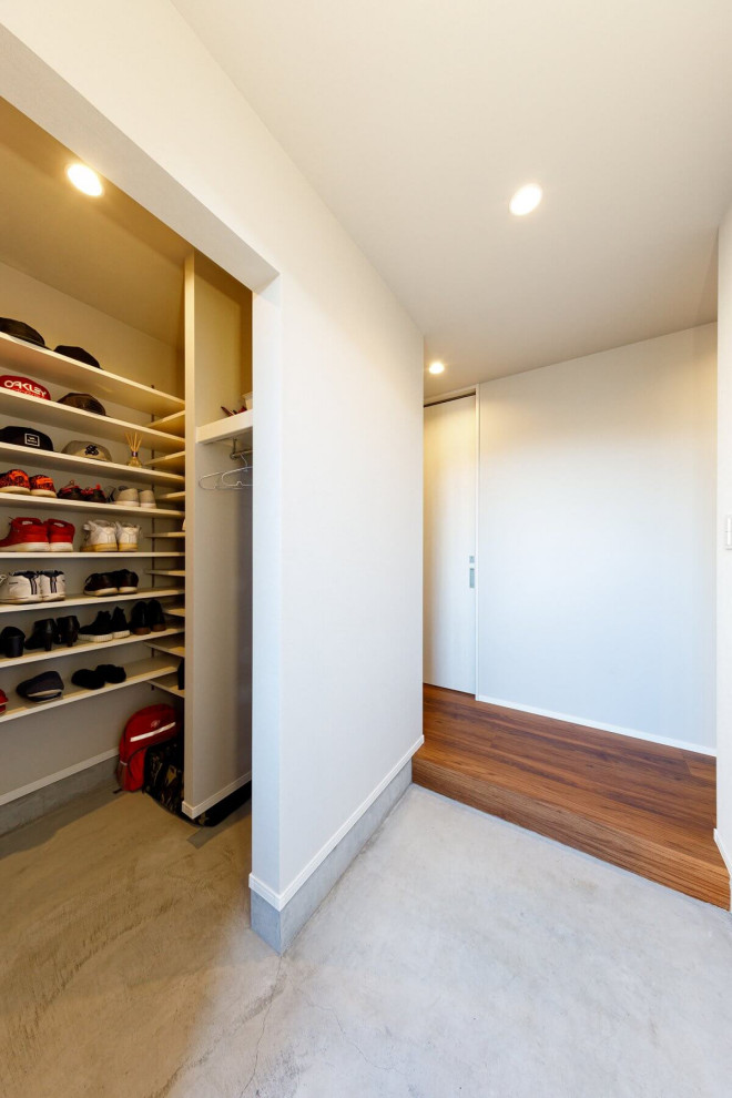 This is an example of a small industrial mudroom in Tokyo Suburbs with white walls, concrete floors, grey floor, wallpaper and wallpaper.