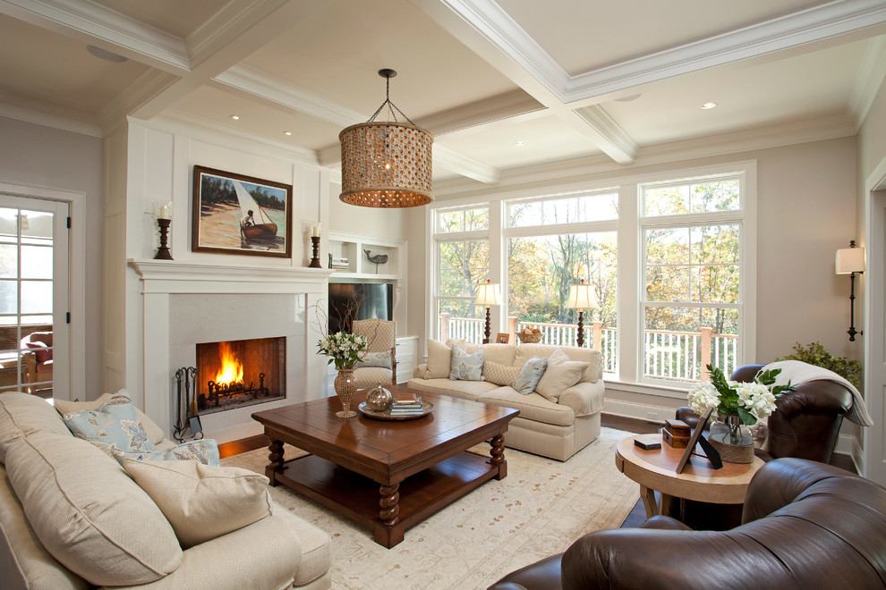 Traditional living room in Minneapolis with beige walls, dark hardwood floors, a standard fireplace and a stone fireplace surround.