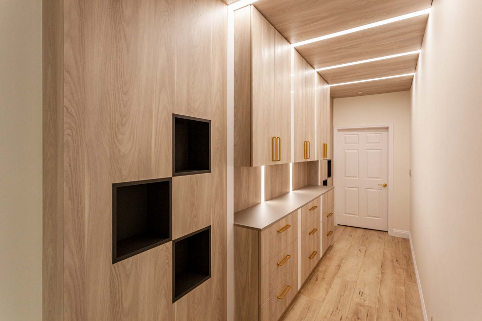 Inspiration for a large modern gender neutral walk-in wardrobe in Los Angeles with flat-panel cabinets, light wood cabinets, vinyl flooring, brown floors and a timber clad ceiling.