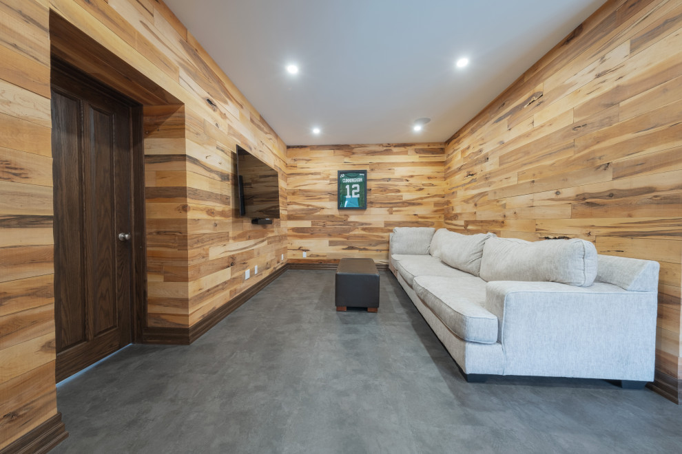 Example of a large mountain style walk-out vinyl floor, gray floor, exposed beam and wood wall basement design with a bar, multicolored walls, a standard fireplace and a stone fireplace