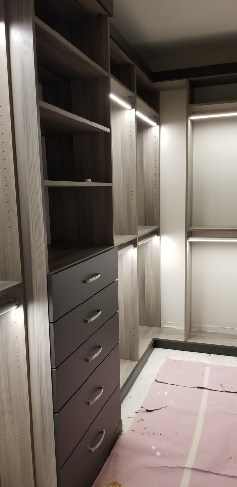 Design ideas for a large modern gender-neutral walk-in wardrobe in Miami with flat-panel cabinets and dark wood cabinets.
