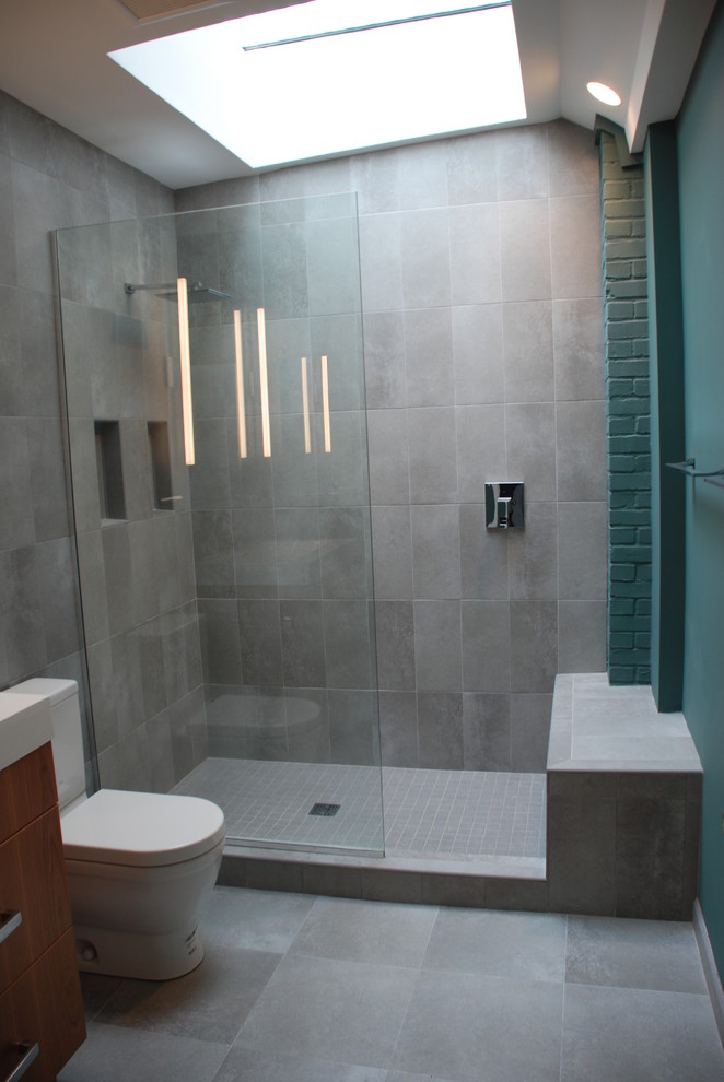 Small contemporary 3/4 bathroom in DC Metro with flat-panel cabinets, medium wood cabinets, an alcove shower, a two-piece toilet, gray tile, porcelain tile, blue walls, porcelain floors and a vessel sink.