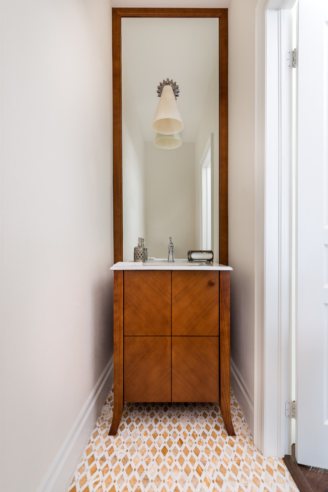 Photo of a small transitional powder room in Toronto with an integrated sink, flat-panel cabinets, medium wood cabinets, multi-coloured tile and marble floors.