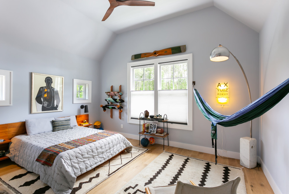 Example of a large transitional light wood floor and vaulted ceiling kids' room design in Charleston with blue walls