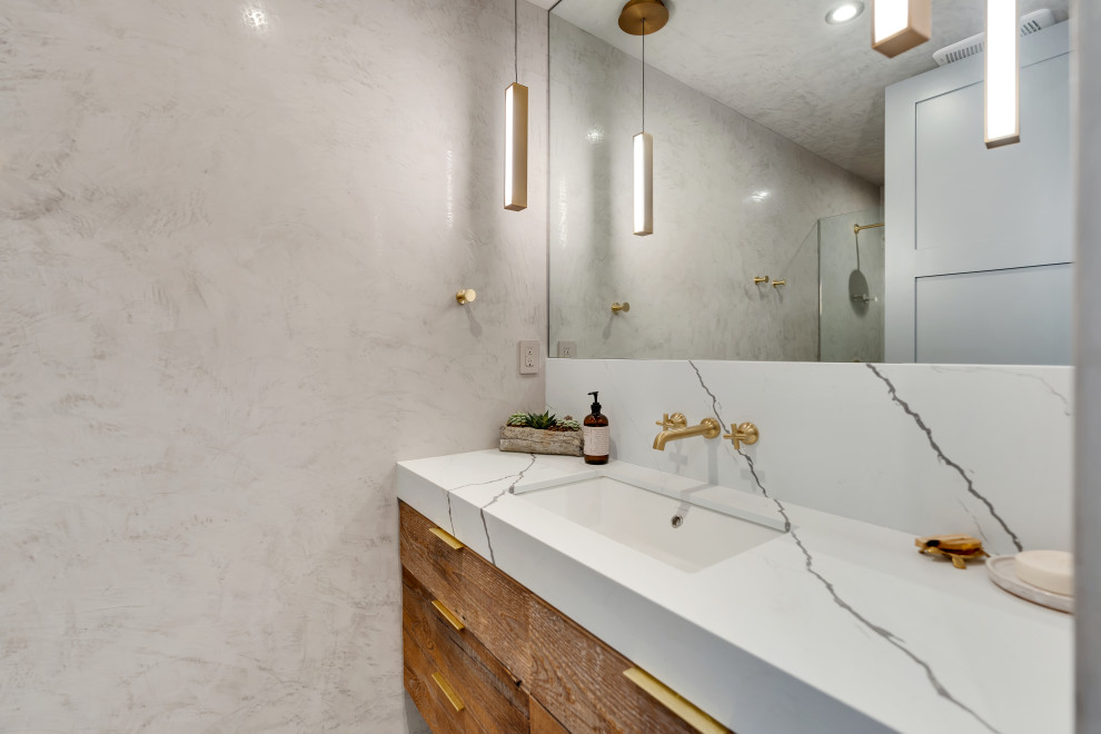 Inspiration for a mid-sized modern kids' ceramic tile, gray floor and single-sink corner shower remodel in Los Angeles with flat-panel cabinets, medium tone wood cabinets, a one-piece toilet, gray walls, a console sink, quartzite countertops, a hinged shower door, multicolored countertops, a niche and a floating vanity