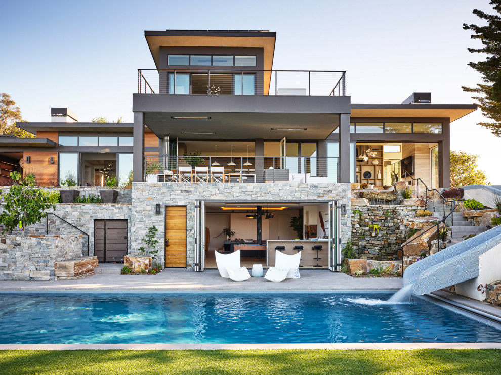 Large contemporary rectangular pool in San Francisco with a water slide and concrete pavers.