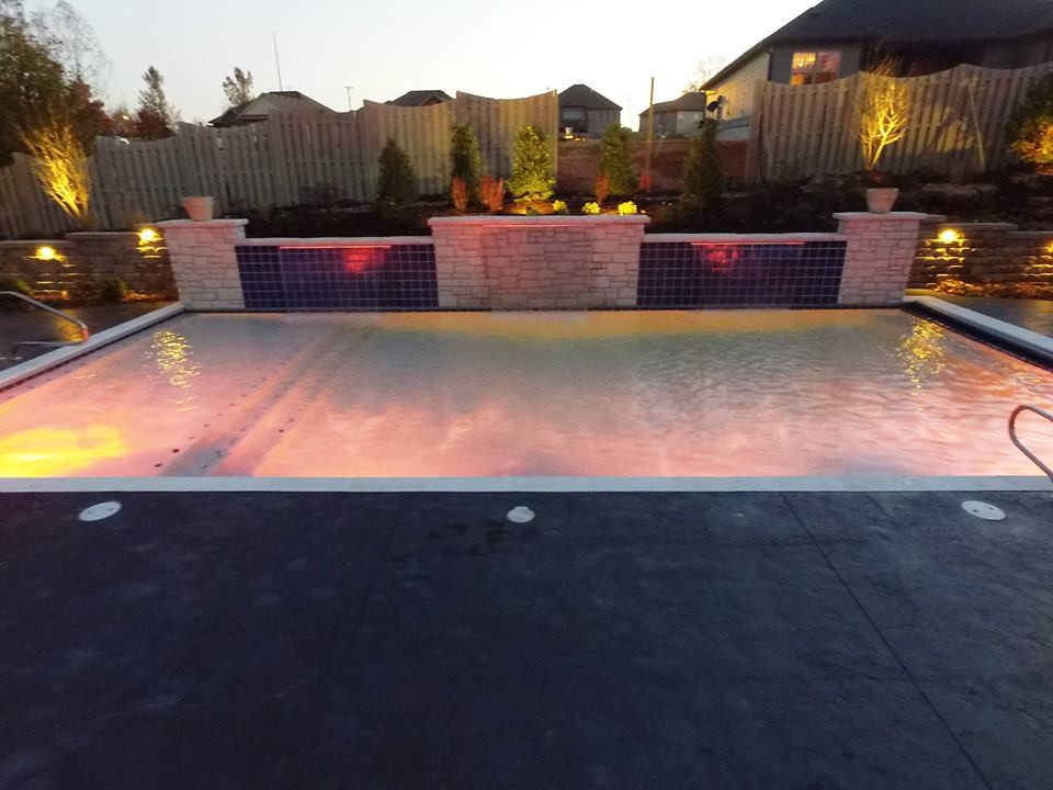 Example of a mid-sized transitional backyard stamped concrete and rectangular pool fountain design