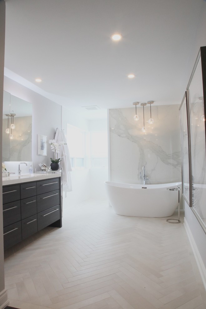 Design ideas for a mid-sized modern master bathroom in Toronto with flat-panel cabinets, dark wood cabinets, a freestanding tub, an open shower, a one-piece toilet, white tile, glass sheet wall, grey walls, porcelain floors, an integrated sink, quartzite benchtops, beige floor, an open shower and white benchtops.