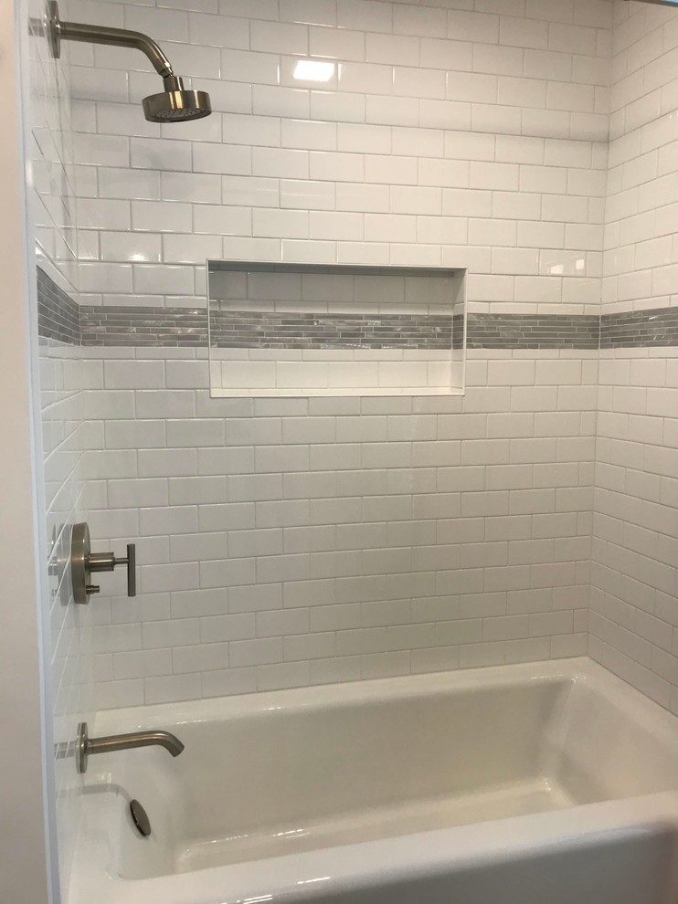 Inspiration for a medium sized traditional family bathroom in Boston with shaker cabinets, white cabinets, an alcove shower, a two-piece toilet, white tiles, porcelain tiles, white walls, porcelain flooring, a submerged sink, engineered stone worktops, grey floors, a shower curtain and black worktops.
