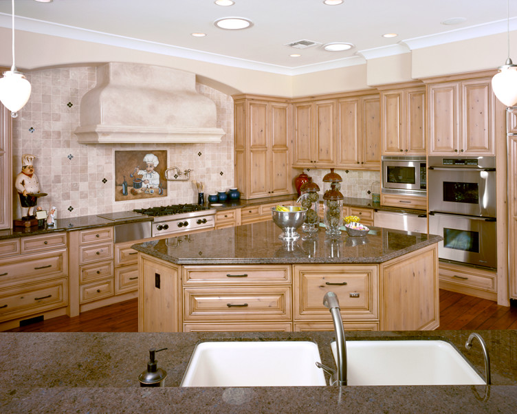 Eat-in kitchen - large rustic l-shaped dark wood floor eat-in kitchen idea in Sacramento with a double-bowl sink, raised-panel cabinets, light wood cabinets, granite countertops, beige backsplash, ceramic backsplash, stainless steel appliances and an island