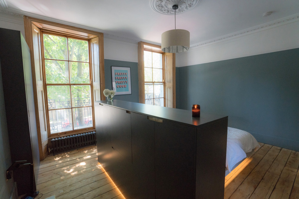 Foto de dormitorio principal clásico grande sin chimenea con paredes grises, suelo de madera clara, suelo marrón y panelado
