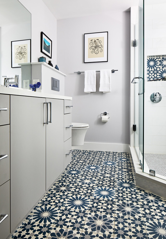 Design ideas for a mid-sized contemporary master bathroom in DC Metro with flat-panel cabinets, grey cabinets, a corner shower, a wall-mount toilet, white tile, grey walls, a hinged shower door and white benchtops.