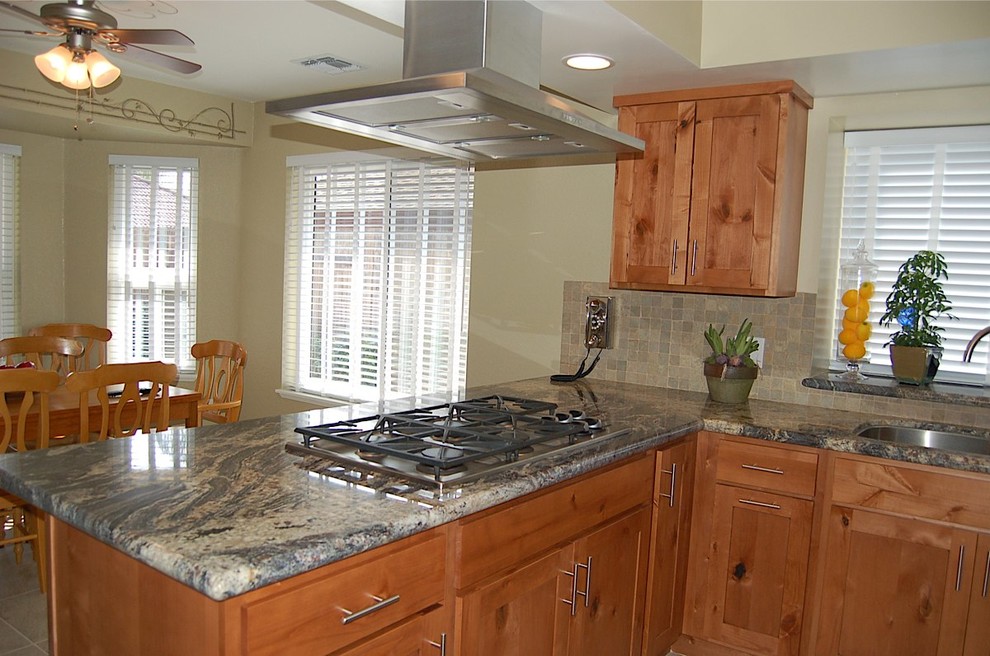 Eat-in kitchen - mid-sized rustic u-shaped porcelain tile eat-in kitchen idea with an undermount sink, shaker cabinets, medium tone wood cabinets, granite countertops, green backsplash, stone tile backsplash, stainless steel appliances and no island