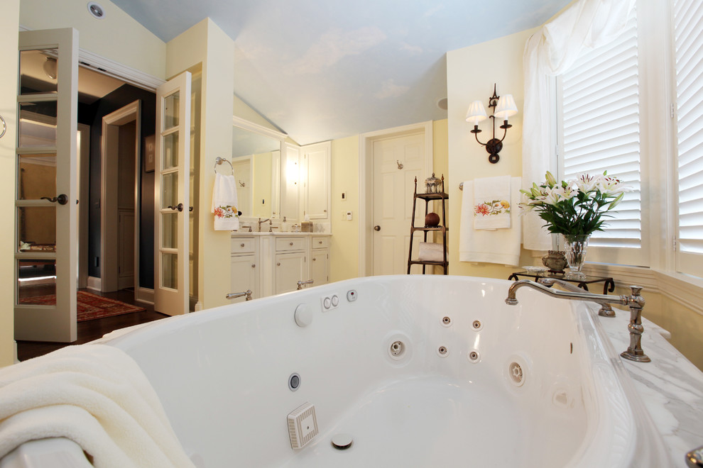 Inspiration for a traditional bathroom in Cleveland with an undermount sink, recessed-panel cabinets, white cabinets, marble benchtops, a hot tub, an alcove shower and a two-piece toilet.