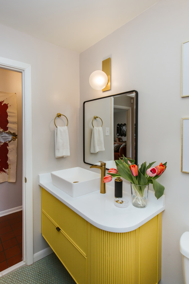 Aménagement d'une salle de bain rétro pour enfant avec des portes de placard jaunes, un sol en galet, une vasque, un sol vert, un plan de toilette blanc, meuble simple vasque et meuble-lavabo suspendu.