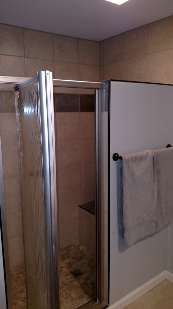 Inspiration for a mid-sized transitional master porcelain tile and beige floor corner bathtub remodel with shaker cabinets, black cabinets, a two-piece toilet, gray walls, an undermount sink, laminate countertops, a hinged shower door and beige countertops