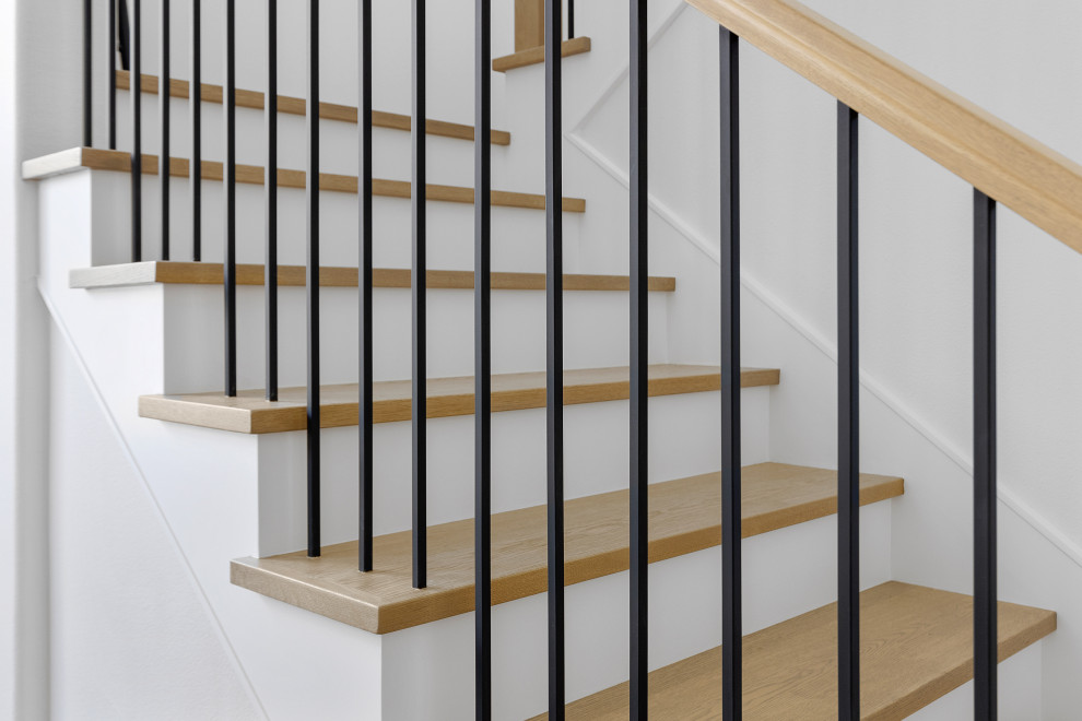 На фото: угловая лестница среднего размера в стиле модернизм с деревянными ступенями и перилами из смешанных материалов с