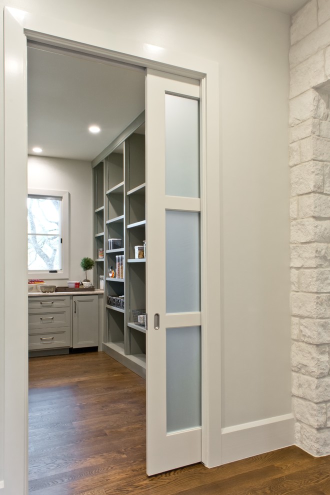 Inspiration for a transitional l-shaped medium tone wood floor open concept kitchen remodel in Austin with an undermount sink, recessed-panel cabinets, green cabinets, quartzite countertops, green backsplash, stone slab backsplash, paneled appliances and an island