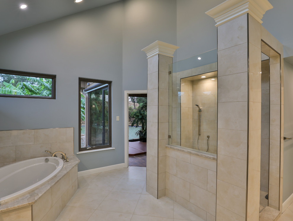 Design ideas for a bathroom in Dallas with raised-panel cabinets, a drop-in tub, a double shower, a one-piece toilet, blue tile, porcelain tile, blue walls, porcelain floors, an undermount sink, granite benchtops, beige floor, an open shower and blue benchtops.