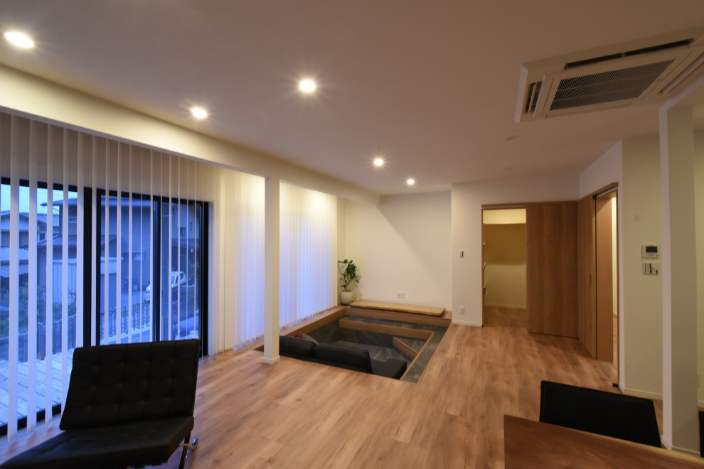 Large modern home theatre in Kobe with white walls, plywood floors and brown floor.