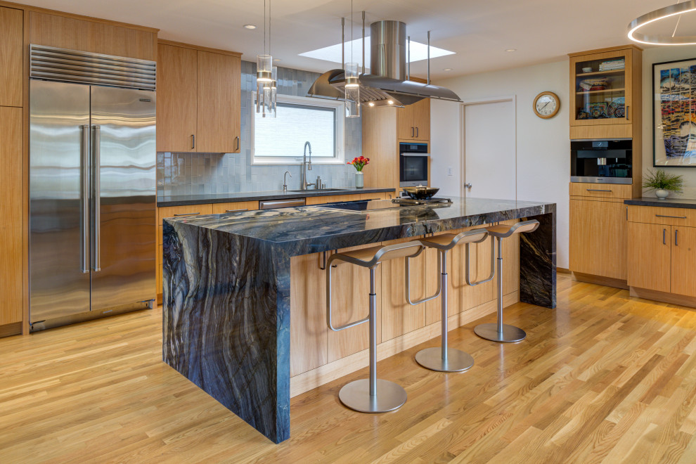 Moderne Küche in L-Form mit Unterbauwaschbecken, flächenbündigen Schrankfronten, hellbraunen Holzschränken, Küchengeräten aus Edelstahl, braunem Holzboden, Kücheninsel, braunem Boden und grauer Arbeitsplatte in San Francisco