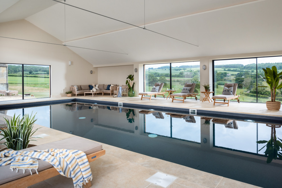 На фото: большой прямоугольный бассейн в доме в стиле кантри с покрытием из каменной брусчатки