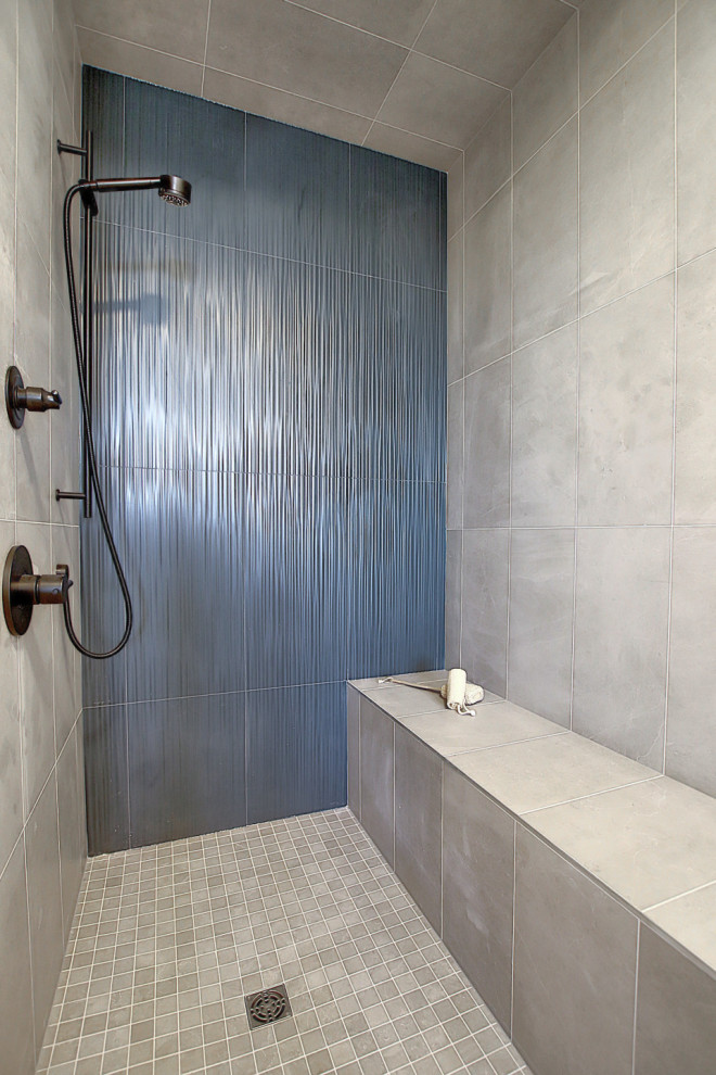 Inspiration for a mid-sized industrial master bathroom in Calgary with flat-panel cabinets, grey cabinets, a freestanding tub, a curbless shower, a two-piece toilet, blue tile, ceramic tile, grey walls, ceramic floors, an undermount sink, engineered quartz benchtops, grey floor, a shower curtain, white benchtops, a shower seat, a double vanity and a floating vanity.