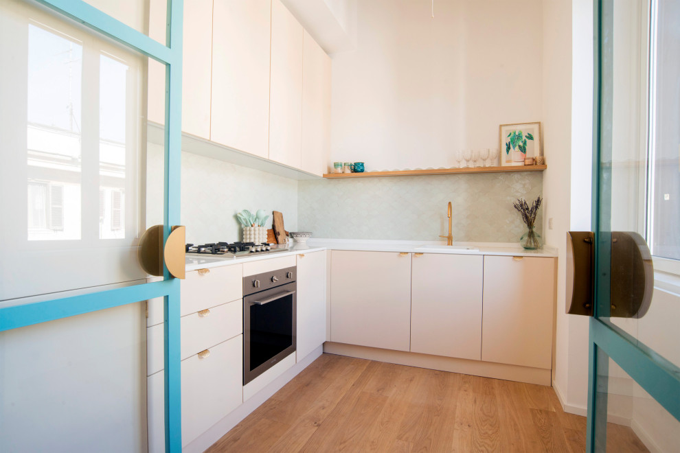 Idéer för att renovera ett avskilt, litet funkis vit vitt l-kök, med en nedsänkt diskho, släta luckor, bänkskiva i kvarts, stänkskydd i keramik, rostfria vitvaror, ljust trägolv och brunt golv