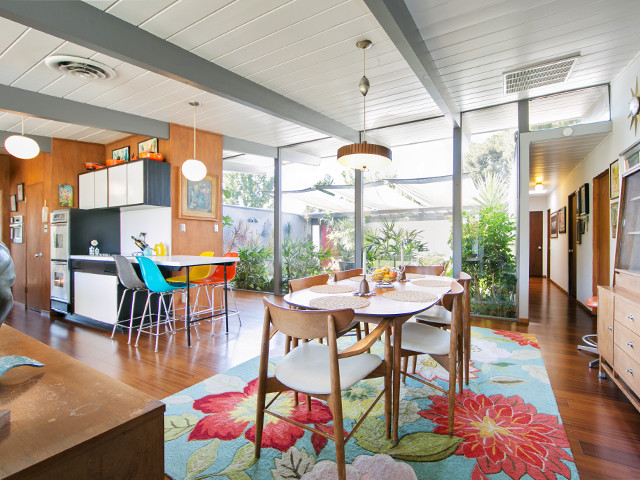 This is an example of a mid-sized midcentury kitchen/dining combo in Orange County with white walls, medium hardwood floors and no fireplace.