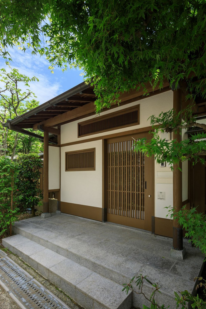 Großer Klassischer Eingang mit weißer Wandfarbe, Granitboden, grauem Boden, freigelegten Dachbalken und Holzdielenwänden in Osaka