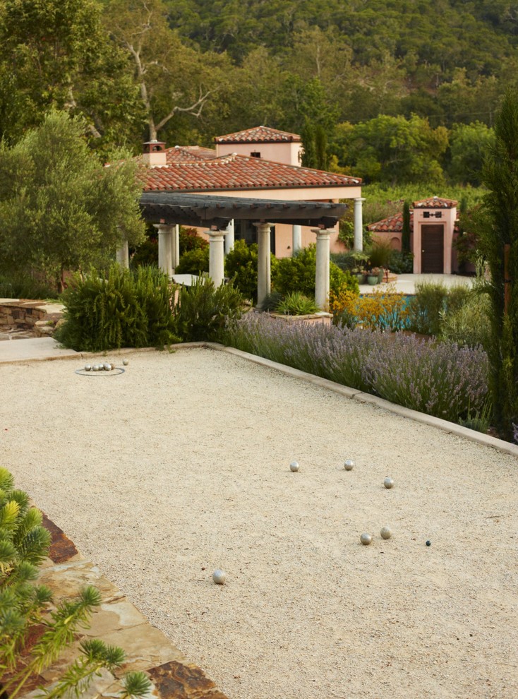 Mediterranean backyard outdoor sport court in San Luis Obispo with gravel.